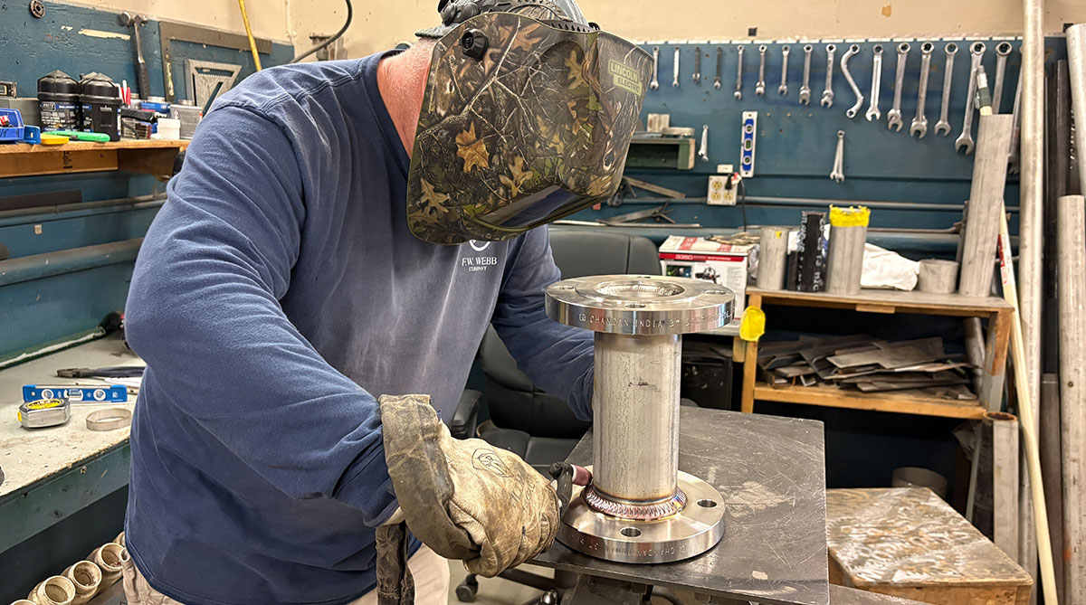 F.W. Webb welder fabricating a stainless steel flanged pipe assembly